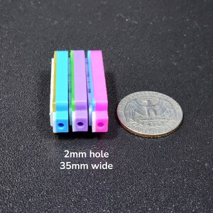 以下が含まれることがあります： 各々2mmの穴が開いたカラフルなプラスチック製のストリップが4本。ストリップは青、緑、紫、ピンク。ストリップの幅は35mm。  2mm hole 35mm wide