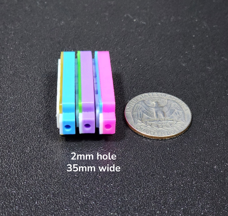 以下が含まれることがあります： 各々2mmの穴が開いたカラフルなプラスチック製のストリップが4本。ストリップは青、緑、紫、ピンク。ストリップの幅は35mm。  2mm hole 35mm wide