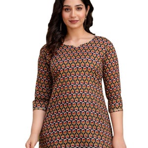 Puede incluir: Top de manga tres cuartos con estampado floral en rojo, amarillo y blanco sobre fondo negro. El top tiene cuello redondo y se combina con vaqueros azul claro. Las mangas tienen detalles dorados.