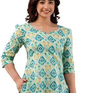 Puede incluir: Top de manga tres cuartos con cuello en V. Presenta un estampado geom&eacute;trico en tonos turquesa, amarillo y blanco. El top tiene un corte holgado y est&aacute; hecho de una tela ligera.
