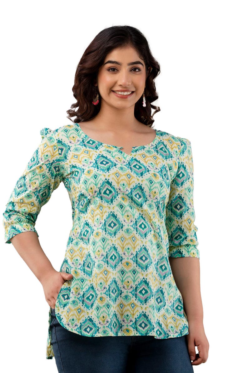 Puede incluir: Top de manga tres cuartos con cuello en V. Presenta un estampado geom&eacute;trico en tonos turquesa, amarillo y blanco. El top tiene un corte holgado y est&aacute; hecho de una tela ligera.