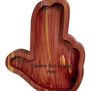 May include: A wooden tray in the shape of a hand, featuring a natural wood grain pattern with reddish-brown and yellow hues. The tray has a carved-out area for holding items and includes the text "Custom Text or Logo Here".