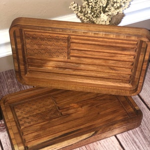 May include: Two wooden cutting boards with an American flag design carved into the surface. The boards are stacked on top of each other.