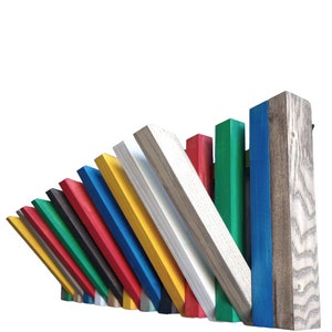 May include: A colorful wooden coat rack with 12 hooks in various colors, including red, green, blue, yellow, and white. The rack is made of wood and has a natural wood finish.