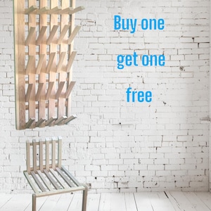 May include: Wooden wall-mounted coat rack with multiple pegs and a matching folding chair. The rack is made of light-colored wood and has a rectangular shape. The chair has a slatted seat and back.