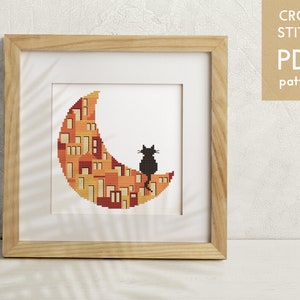 May include: A cross stitch pattern featuring a black cat sitting on a crescent moon with a cityscape design. The moon is filled with orange, yellow, and red houses.