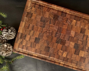 May include: A large, rectangular, wooden cutting board with a checkered pattern. The board is made of dark wood with a natural finish.