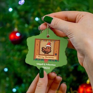 Peut inclure: Ornement de Noël vert et marron en forme de flocon de neige avec un poulet de dessin animé portant un chapeau de Père Noël. L'ornement dit "Joyeux Noël" et "Diplôme d'Abigail 2021".
