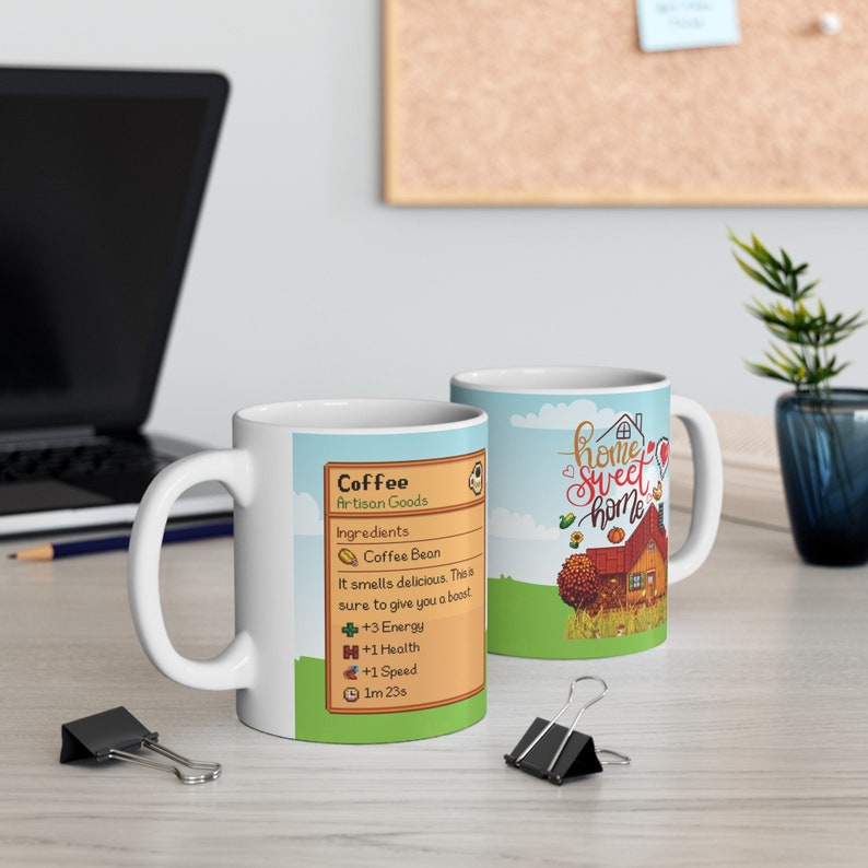 May include: Two white ceramic mugs with different designs. One mug features a cartoon illustration of a coffee bean and the text "Coffee Artisan Goods" with a list of ingredients and effects. The other mug features a cartoon illustration of a house with the text "Home Sweet Home".