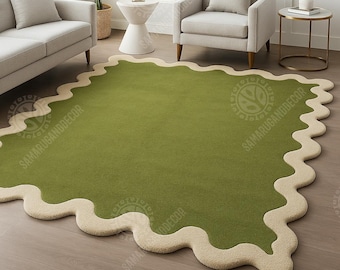 May include: A green rug with a wavy, cream-colored border. The rug is rectangular with rounded corners and a soft, plush texture. The rug is placed on a hardwood floor in a living room setting.