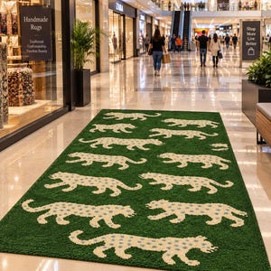 May include: A rectangular area rug featuring a deep green background with a repeating pattern of off-white leopards. Each leopard has small blue spots across its body. The rug is laid out on a polished floor in a shopping mall corridor.