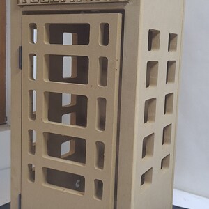 May include: A brown wooden model of a classic British telephone box with a crown on top and the word "TELEPHONE" inscribed on the front.