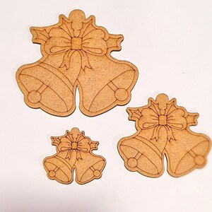 May include: Three wooden Christmas bells with bows. The bells are in different sizes and are ready to be painted.