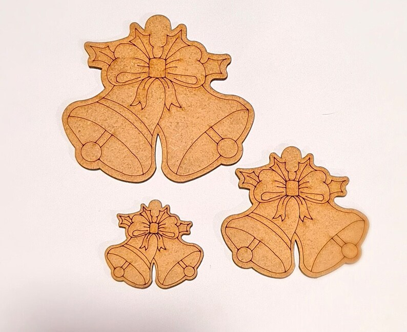 May include: Three wooden Christmas bells with bows. The bells are in different sizes and are ready to be painted.