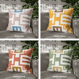 May include: Four decorative throw pillows with geometric patterns in various colors. The pillows are arranged on a couch with a light gray fabric. The pillows are labeled "Rosey Sky", "Canary Spice", "Healing Coral", and "Golden Bamboo".
