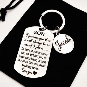 May include: Silver keychain with a tag that reads "SON I promise you that I will always be in one of 3 places... In front of you to cheer you on, behind you to have your back, or next to you so that you aren't walking alone. Love you" and a smaller tag that reads "Jacob".