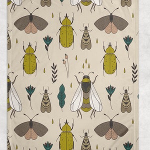 May include: A beige fabric with a repeating pattern of yellow beetles, brown moths, white bees, and green leaves. The pattern is a whimsical and colorful design.