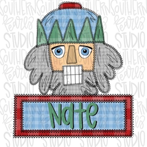 Może przedstawiać: Zielony i niebieski łamacz orzechów w patchworku z czerwonym kapeluszem i etykietą z imieniem "Nate".