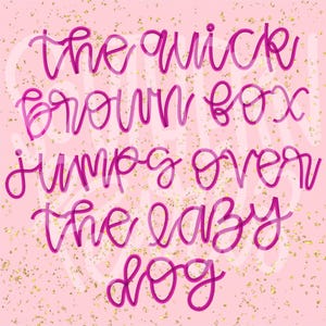 May include: A light pink graphic print featuring the magenta cursive text "the quick brown box jumps over the lazy dog" layered over a background scattered with small, shimmering gold flecks that create a textured, metallic appearance.