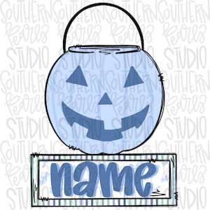 May include: A light blue pumpkin shaped candy bucket with a black handle and a smiling jack-o-lantern face. A blue and white striped sign with the word "name" is below the bucket.