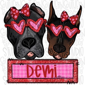 May include: Illustration of two dog faces, one black and one brown, wearing heart-shaped sunglasses and red bows. A rectangular sign below reads "Demi" in red letters, set against a pink plaid background.