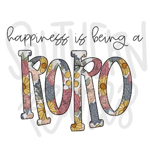 Può includere: La felicità è essere un "ROBO" in lettere con stampa floreale. Le lettere sono contornate di nero e riempite con un motivo floreale di fiori rosa, gialli e blu.