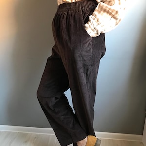 May include: Brown corduroy pants with a wide leg and an elastic waistband.