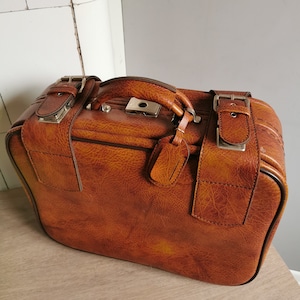Valigia vintage in similpelle marrone con cinturini con fibbia, bagaglio retrò per viaggiatori