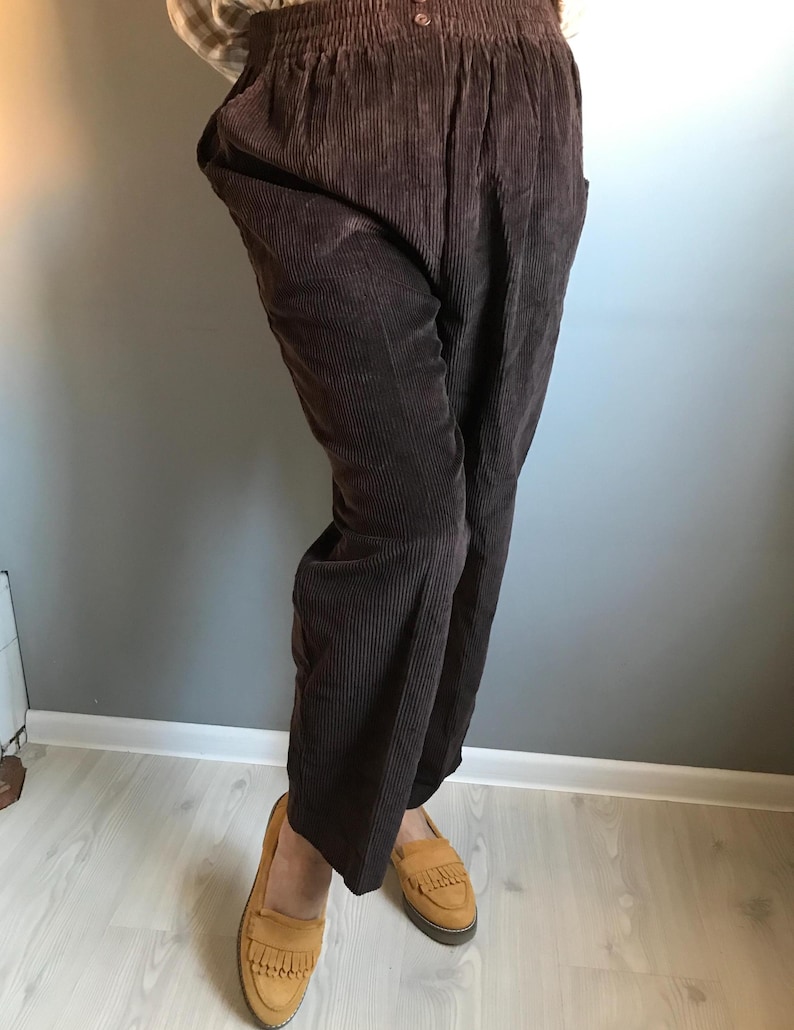 May include: Brown corduroy pants with a wide leg and elastic waistband.