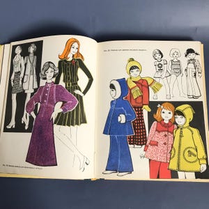 May include: A vintage book with illustrations of clothing patterns for children. The book features a variety of styles, including dresses, coats, and pants. The illustrations are in color and are drawn in a retro style.