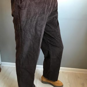 May include: Brown corduroy pants with a wide leg and a relaxed fit. The pants have a drawstring waistband and are made of a soft, comfortable fabric.