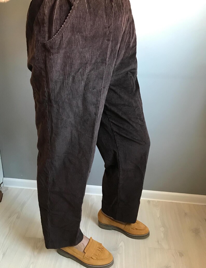 May include: Brown corduroy pants with a wide leg and a relaxed fit. The pants have a drawstring waistband and are made of a soft, comfortable fabric.