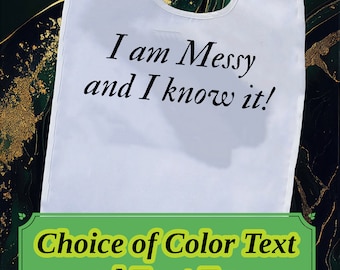 May include: White bib with black text that reads "I am Messy and I know it!"  The text is on a white bib with a green background. The text is in a cursive font.  Choice of Color Text and Font Type is written in a green box with a yellow border.