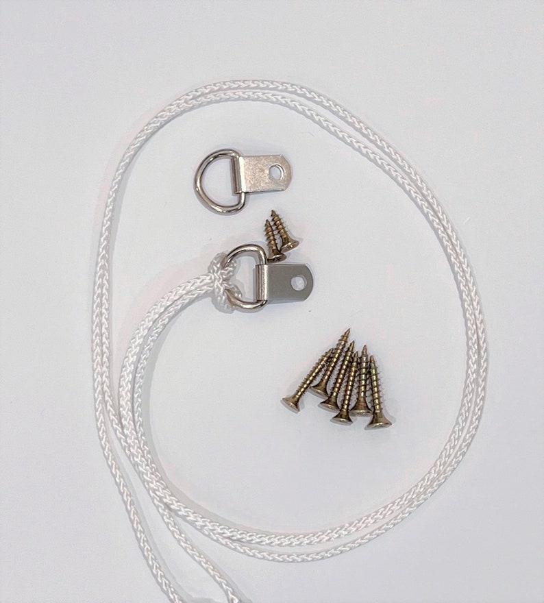 May include: A set of two silver D-rings with a white rope and six gold screws. The D-rings are used for hanging items.