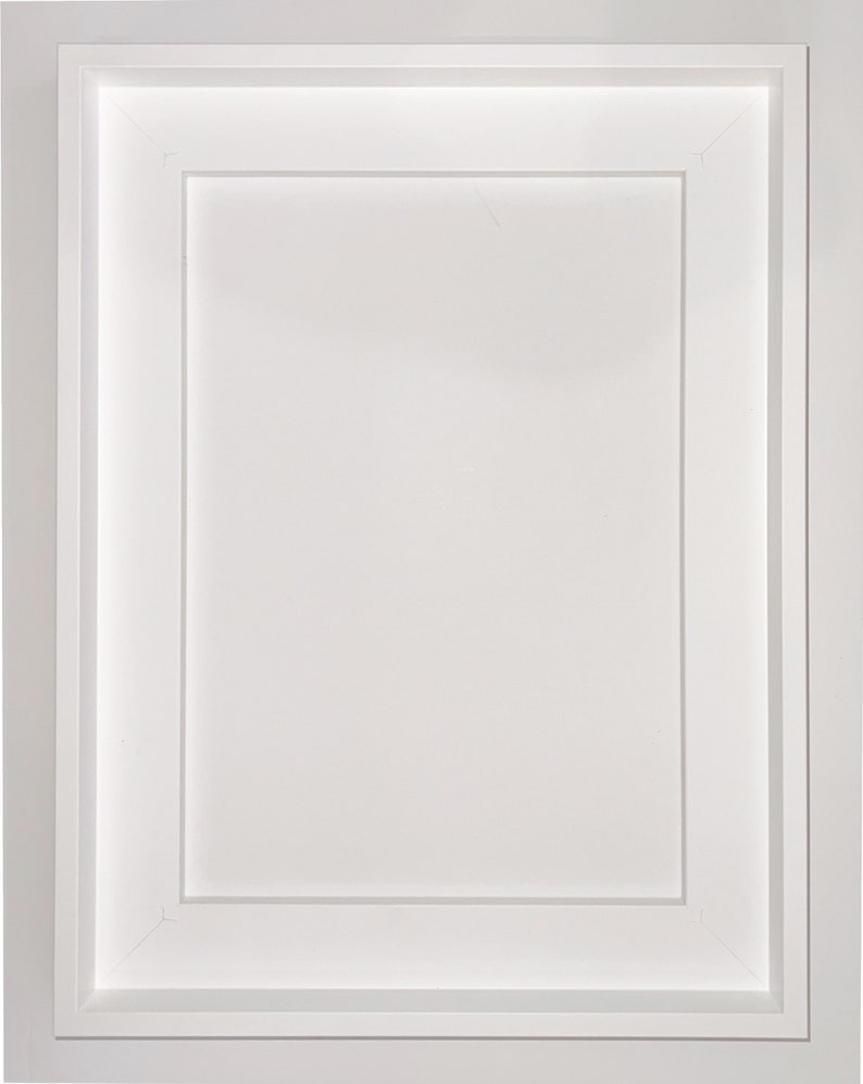 May include: A white picture frame with a double mat, creating a recessed area for a photo or artwork. The frame has a simple, clean design.
