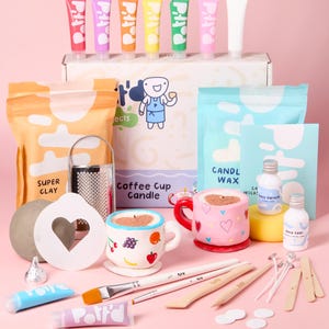 May include: A craft kit for making coffee cup candles. The kit includes clay, candle wax, wicks, paint, and tools. The kit also includes two pre-made ceramic coffee cups, one with a pink glaze and the other with a white glaze and fruit designs.