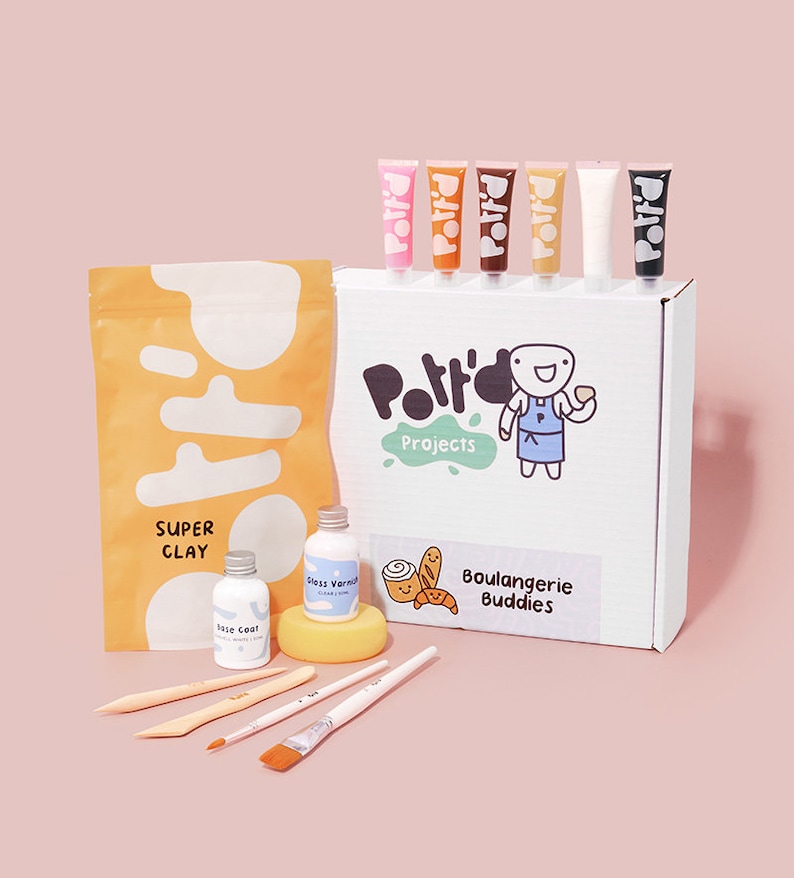May include: A craft kit for making clay bread. The kit includes a bag of clay, six tubes of paint, two bottles of glaze, a sponge, four paintbrushes, and a box with the text "Pottery Projects" and "Boulangerie Buddies".