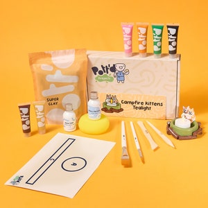 May include: A craft kit for making a tealight with a campfire kitten design. The kit includes clay, paint, brushes, and a tealight holder. The box is labeled "Campfire Kittens Tealight" and "Polito Projects".