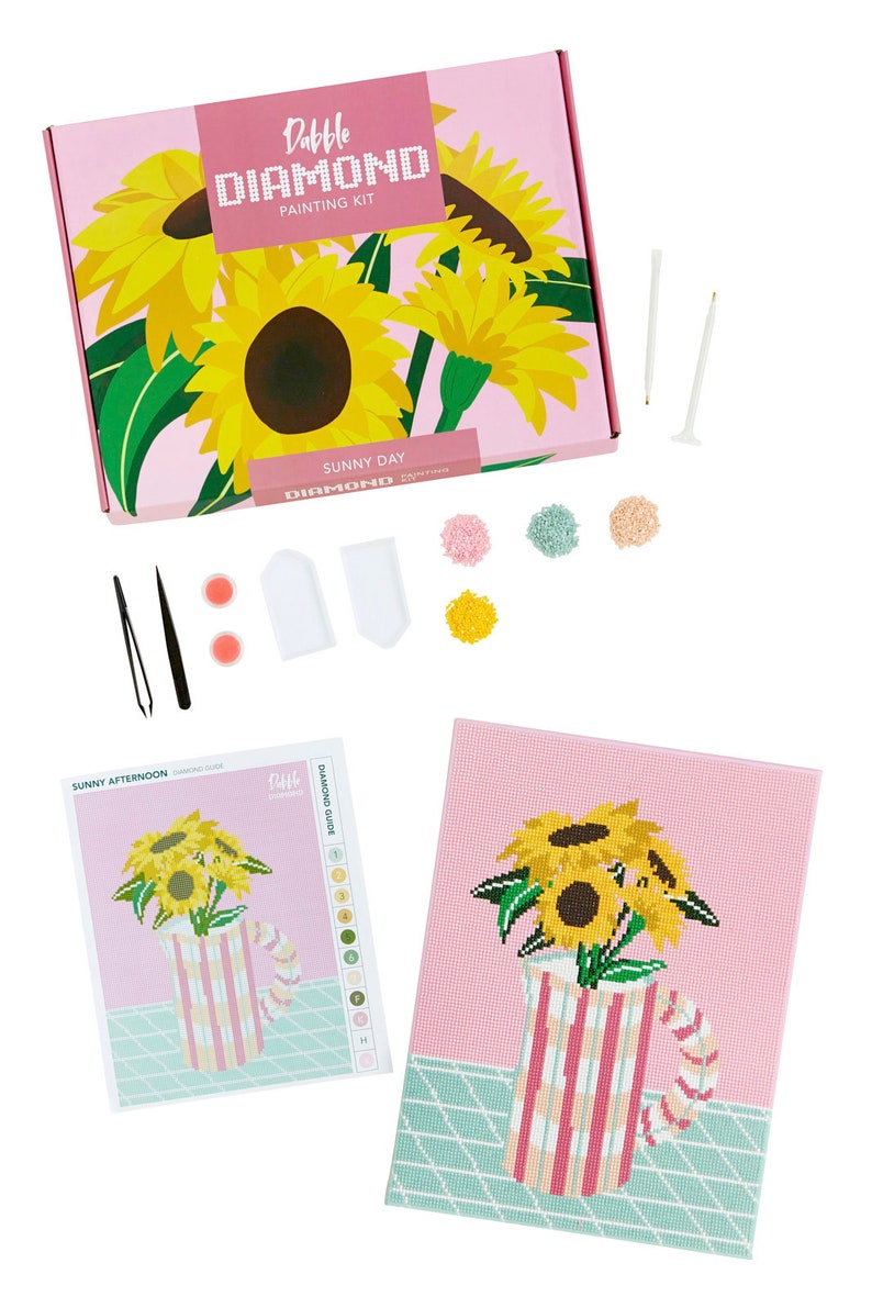 Może przedstawiać: R&oacute;żowe pudełko z wzorem słonecznika i tekstem "Dabble Diamond Painting Kit" i "Sunny Day". Pudełko zawiera pł&oacute;tno, narzędzia i diamentowe koraliki do projektu malowania diamentowego.