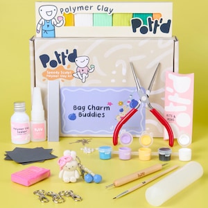 Peut inclure: Un kit de pâte polymère avec le texte "Potr'd" et "Speedy Sculpt Polymer Clay Kit". Le kit comprend de l'argile, des outils, du scellant et un projet "Bag Charm Buddies". Le kit comprend également un porte-clés lapin et une pince à poignée rouge.