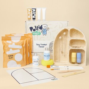May include: A craft kit for making a tiny trinket tower. The kit includes a ceramic tower, super clay, paint, brushes, and a sponge. The box says "Pottery Projects Tiny Trinket Tower".