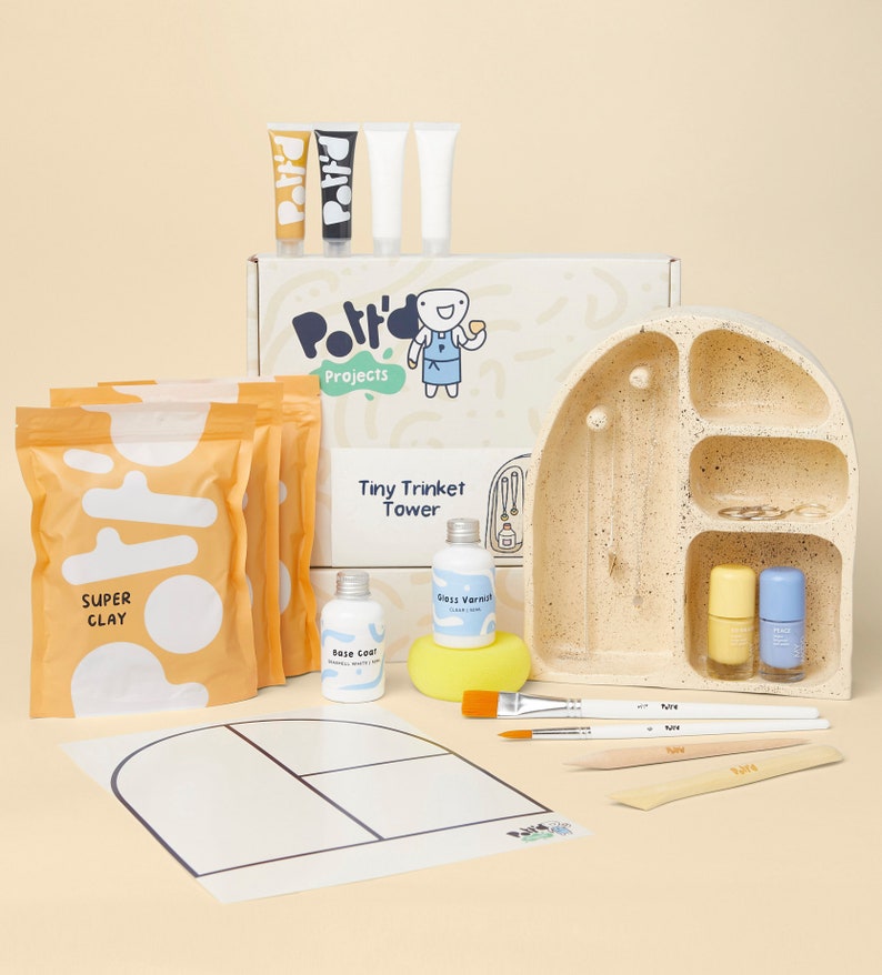 May include: A craft kit for making a tiny trinket tower. The kit includes a ceramic tower, super clay, paint, brushes, and a sponge. The box says "Pottery Projects Tiny Trinket Tower".