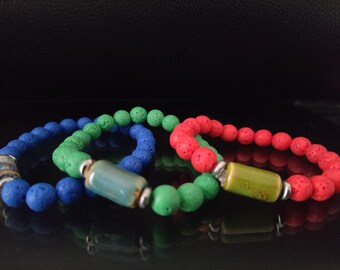 May include: Three lava rock bracelets in blue, green, and red with decorative ceramic beads.