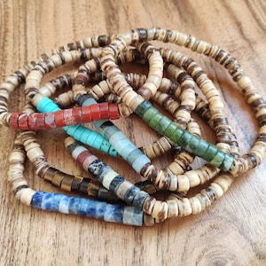 May include: A set of six bracelets made with natural wood beads and colourful gemstone accents. The bracelets feature a variety of colours, including red, green, blue, and turquoise.
