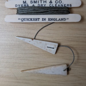 以下が含まれることがあります： 「M. SMITH & CO. DYERS & DRY CLEANERS」と「QUICKEST IN ENGLAND」の文字が入った、ヴィンテージの糸巻き。象牙色の三角形の糸ガイドが2つ、糸に付いています。