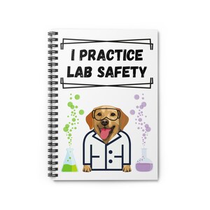 Może przedstawiać: Spiralny notatnik z napisem "I PRACTICE LAB SAFETY". Okładka przedstawia kreskówkowego labradora w goglach ochronnych i fartuchu laboratoryjnym. Na okładce znajdują się również zielone i fioletowe bąbelki i zlewki.
