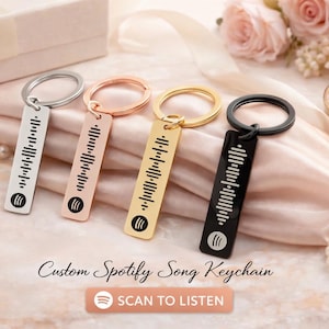 May include: Four keychains in silver, rose gold, gold, and black, each with a Spotify code design. The keychains are rectangular with a circular keyring. The words "Custom Spotify Song Keychain" and "SCAN TO LISTEN" are also visible.
