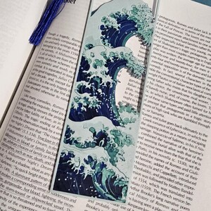 May include: A bookmark featuring a stylized depiction of a large ocean wave in shades of blue and white. The bookmark is rectangular with a blue tassel attached. The text "Romeo and Juliet" is visible.