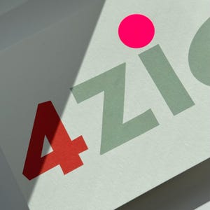 May include: A white card with the text "4ZIC" in green and red letters. A bright pink circle is above the letters.