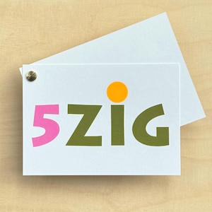 May include: A white rectangular card featuring the text 5ZIG in bold, colorful letters. The number 5 is pink, while the letters Z, I, and G are olive green. A solid orange circle sits above the letter I. A small brass fastener is in the corner.